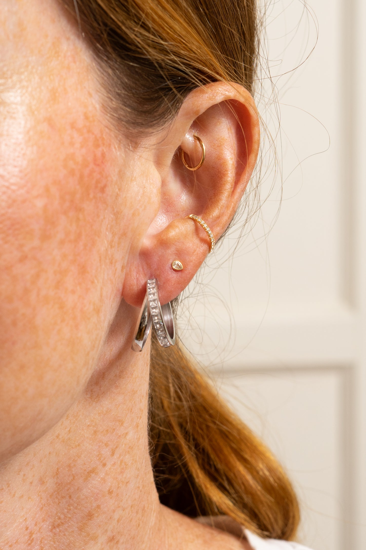 double hoop earring for single piercing on model with multiple ear piercings close-up 